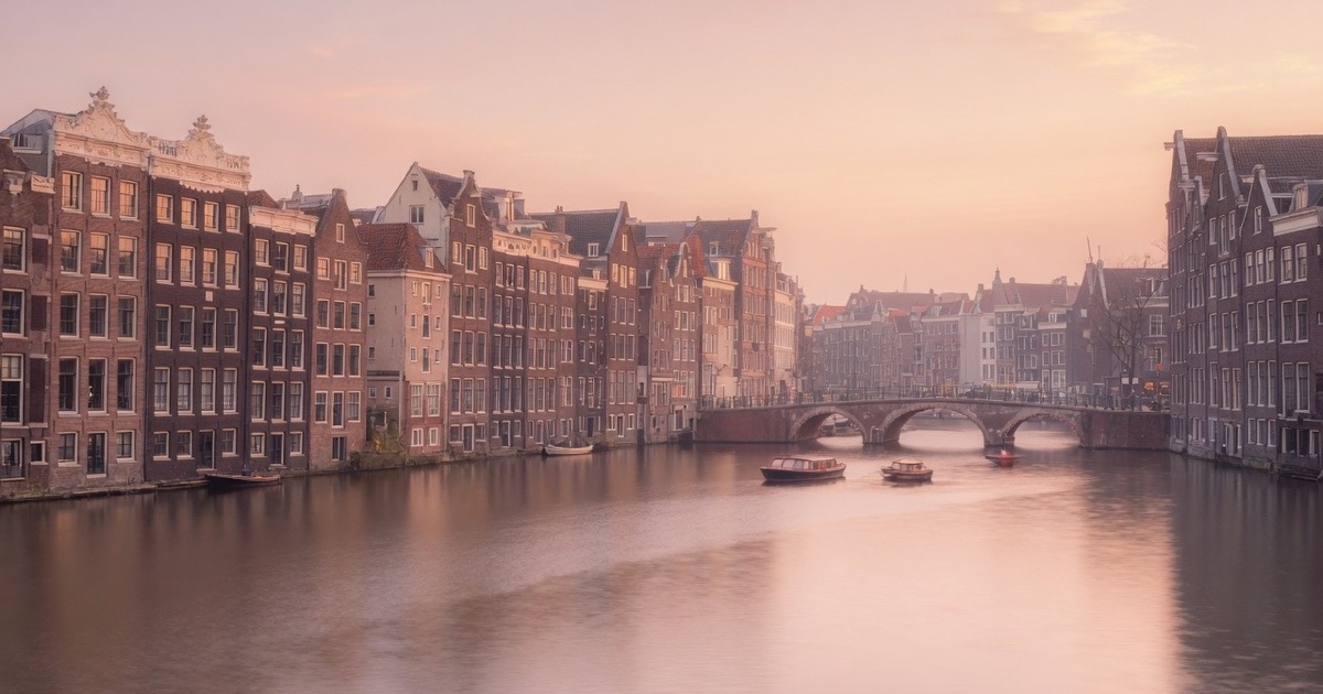 Soft dusk light over Amsterdam canals and green for a first-meet guide